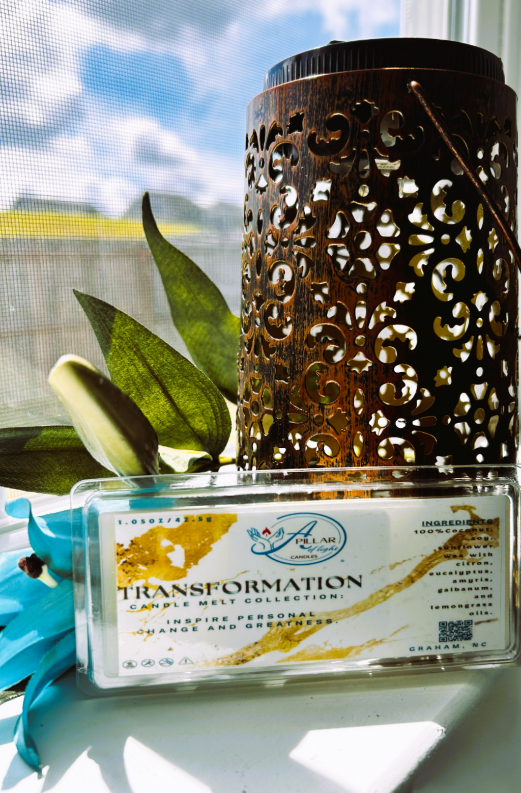 Decorative clamshell melt  'Transformation citron,  eucalyptus wax melt on a windowsill with greenery.